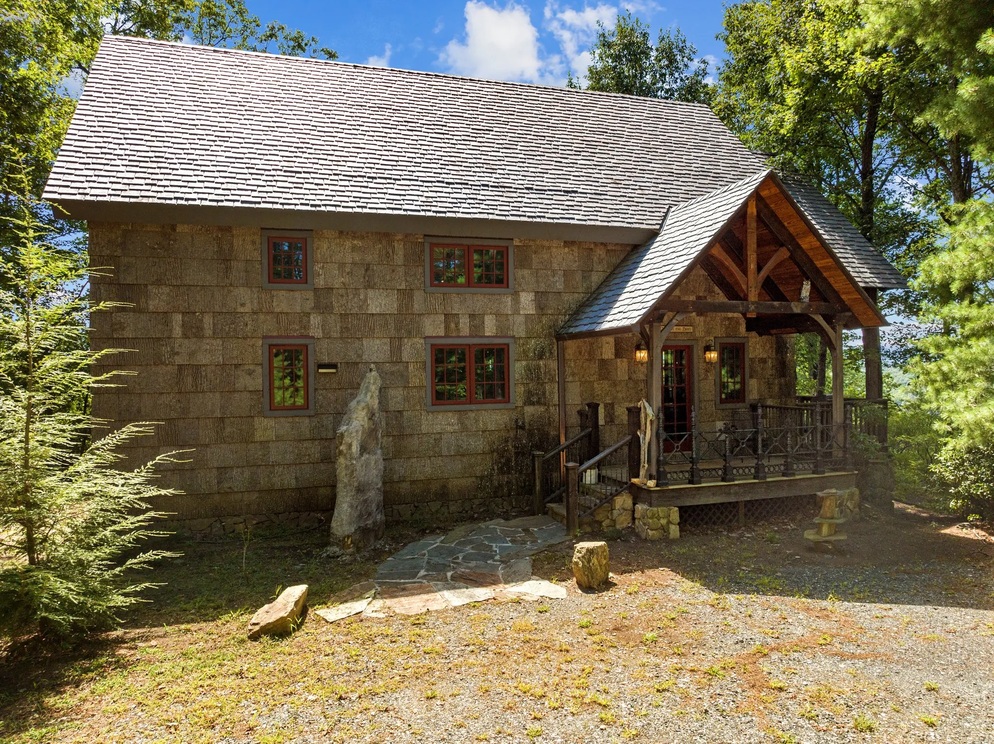 Stunning wood shake Highland cabin with timber frame porch entrance surrounded by mountain forest