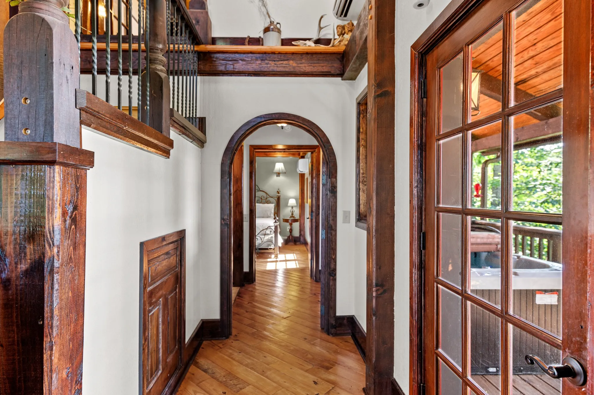 Interior hallway with distinctive arched wooden doorway and hardwood flooring