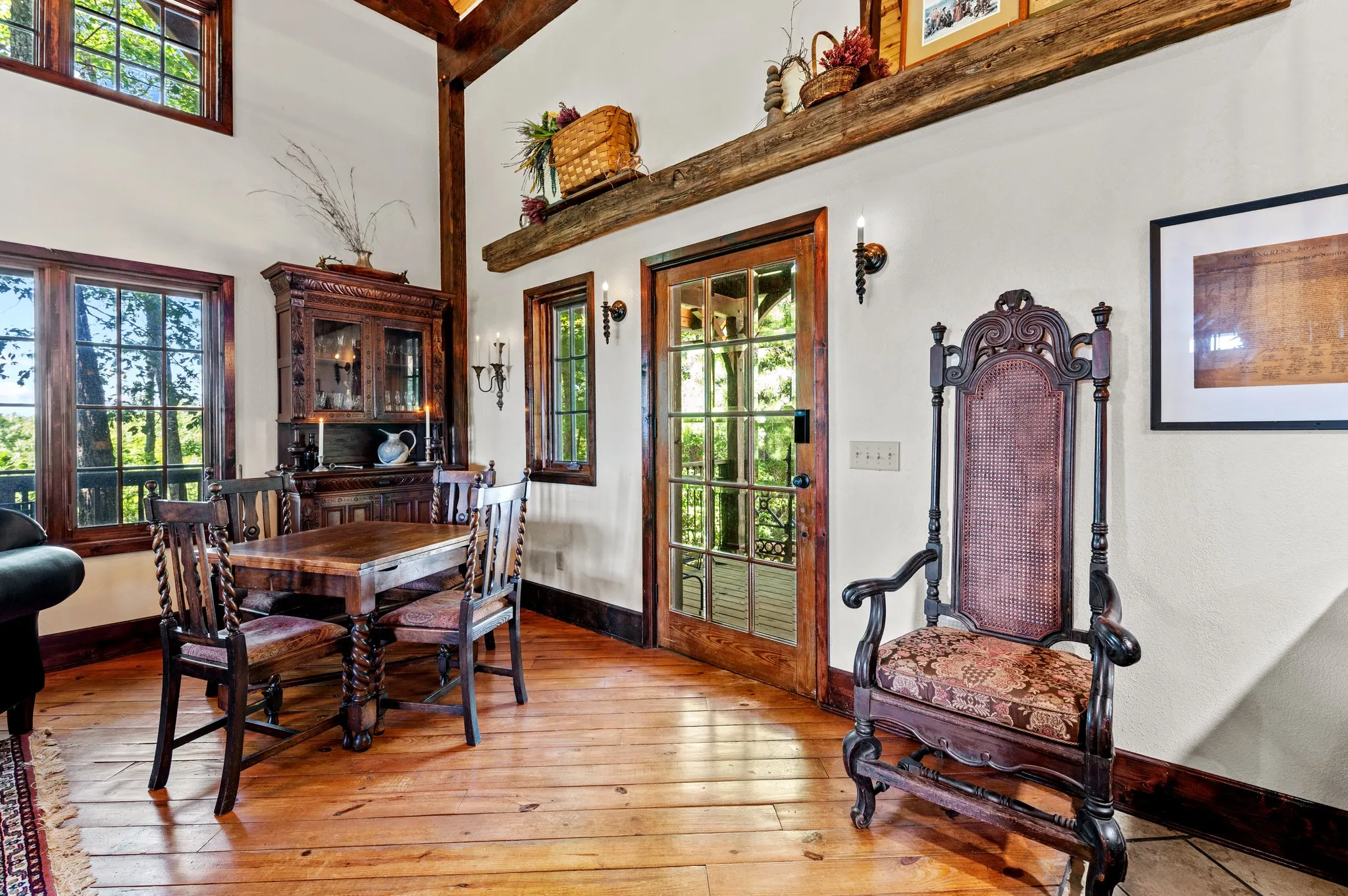 Formal dining area with antique wooden furniture, ornate chair, and tall timber beams
