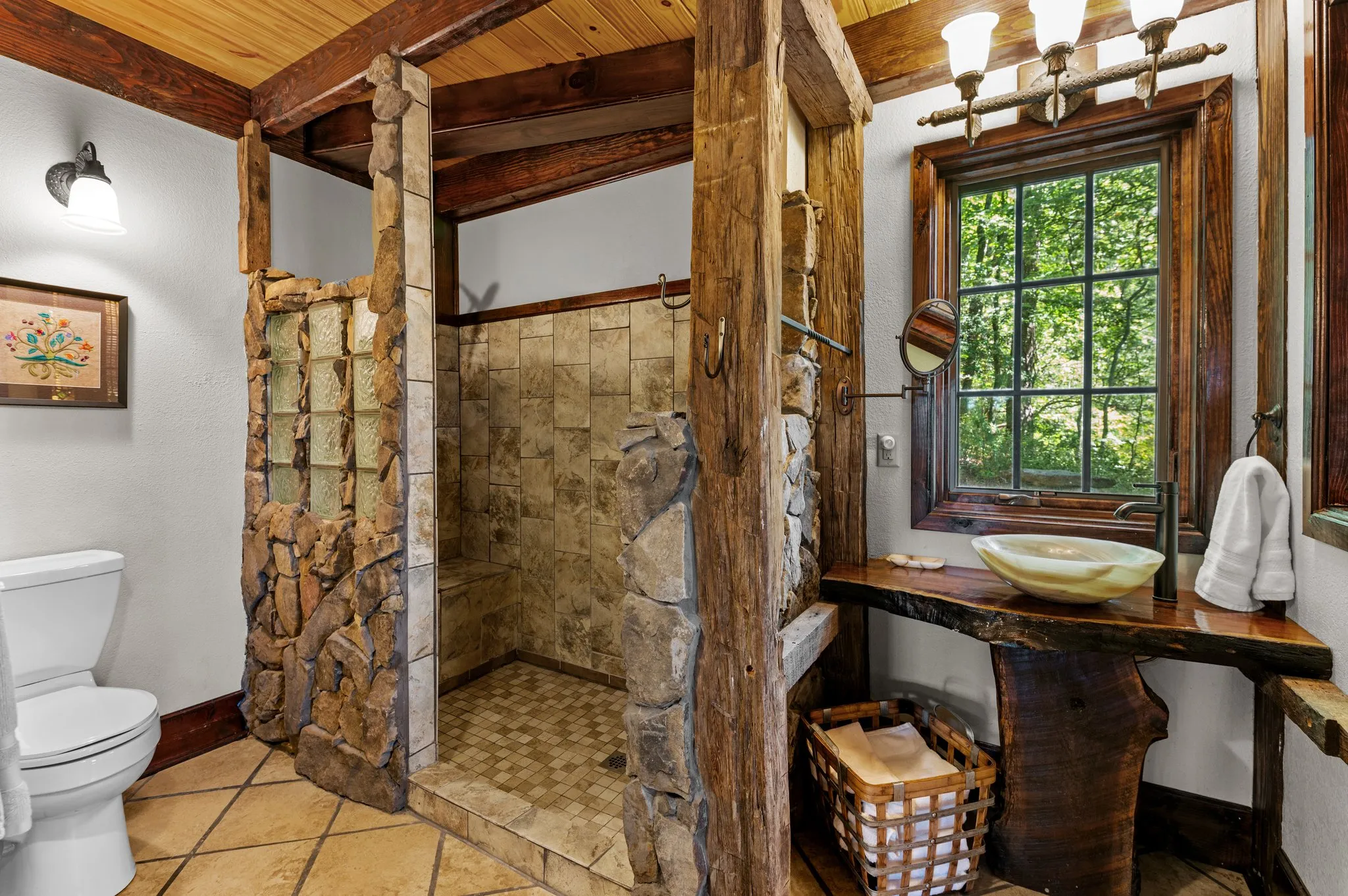 Luxurious bathroom with custom walk-in shower, wooden accents, and large window with forest view