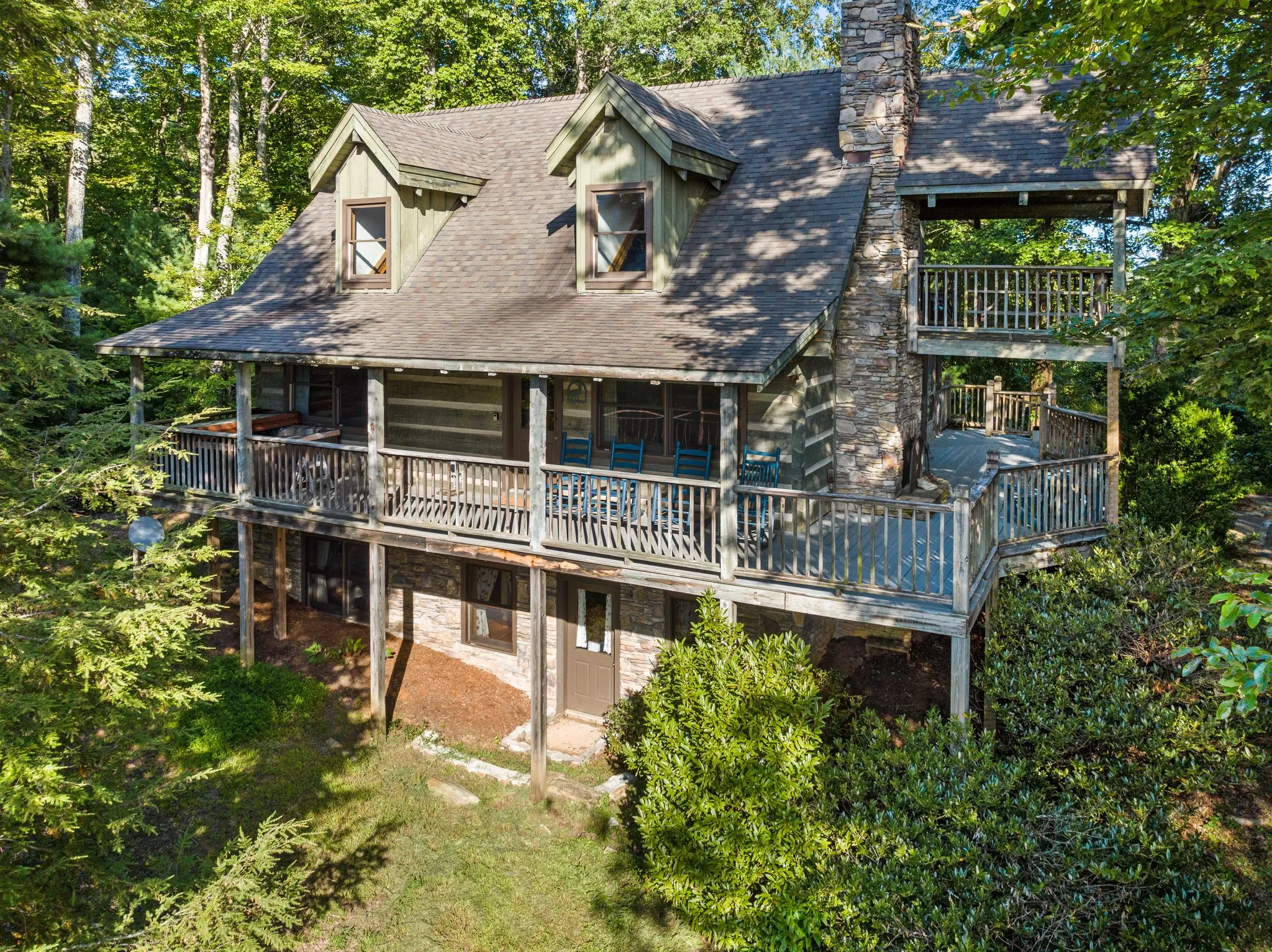 Aerial Cabin View Aerial view of log cabin showing multiple decks, peaked roof, and secluded forest setting