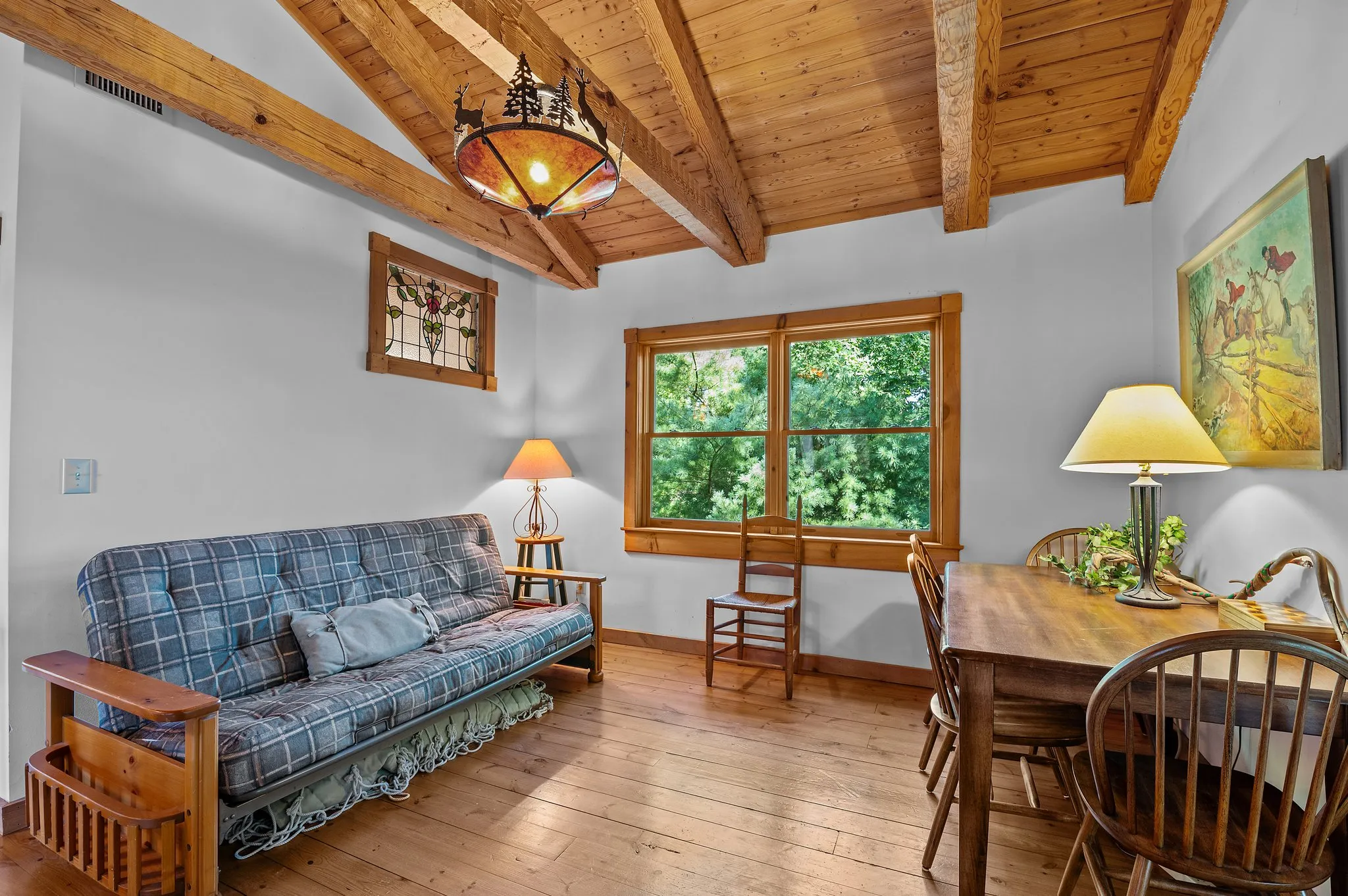 Guest Room Multi-purpose guest room with futon, dining table, exposed beams, and rustic chandelier