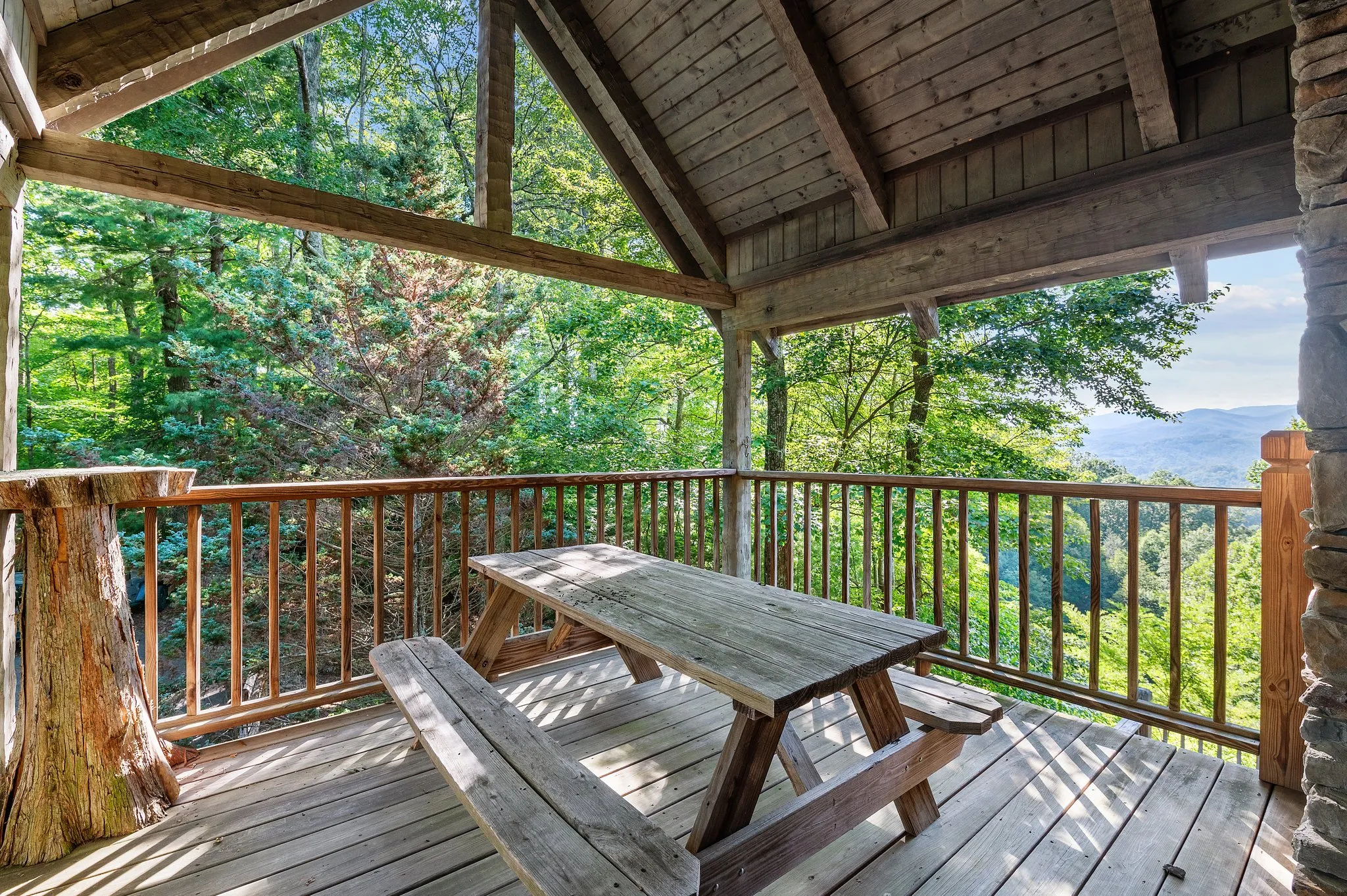 Covered Deck with Vista Covered deck with picnic table and sweeping mountain valley views through forest trees