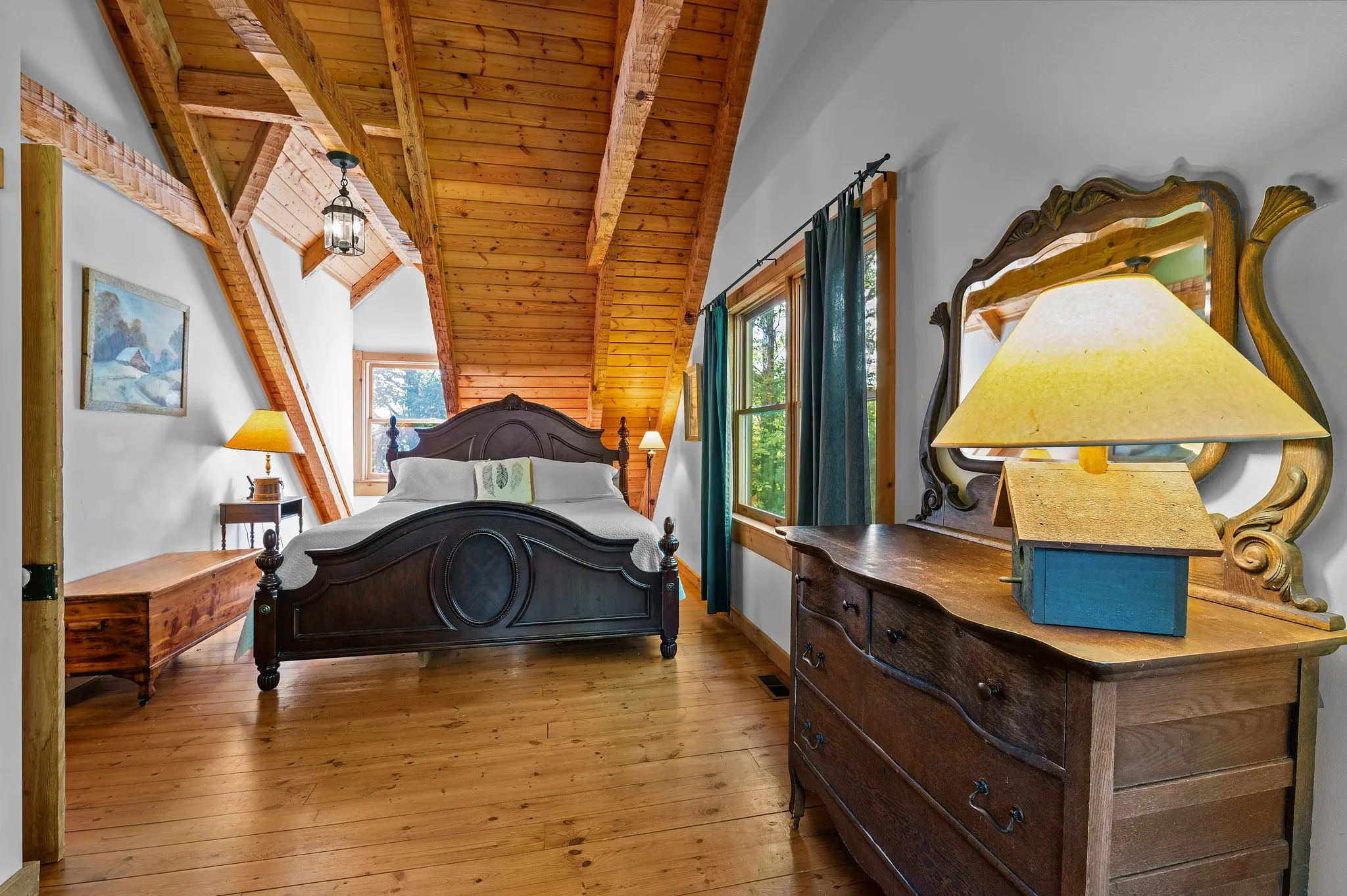 Upstairs Master Bedroom Spacious upstairs bedroom with vaulted ceiling, dark wood bed, antique dresser with ornate mirror
